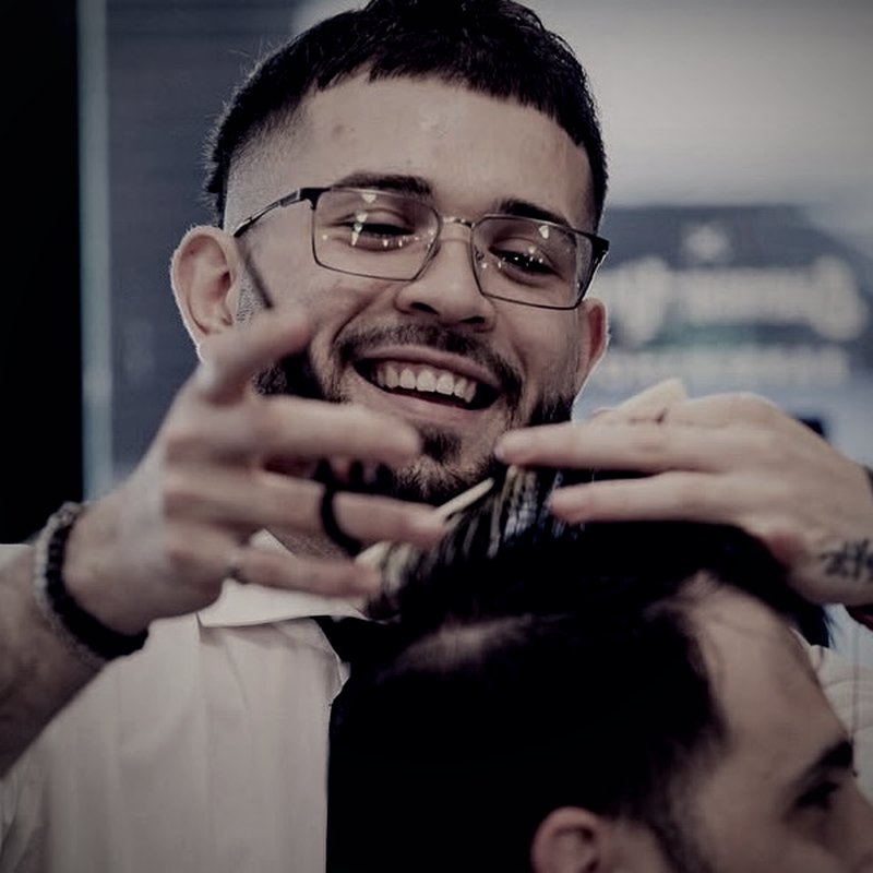 Alejandro Zabala sonriendo mientras trabaja sobre un cliente